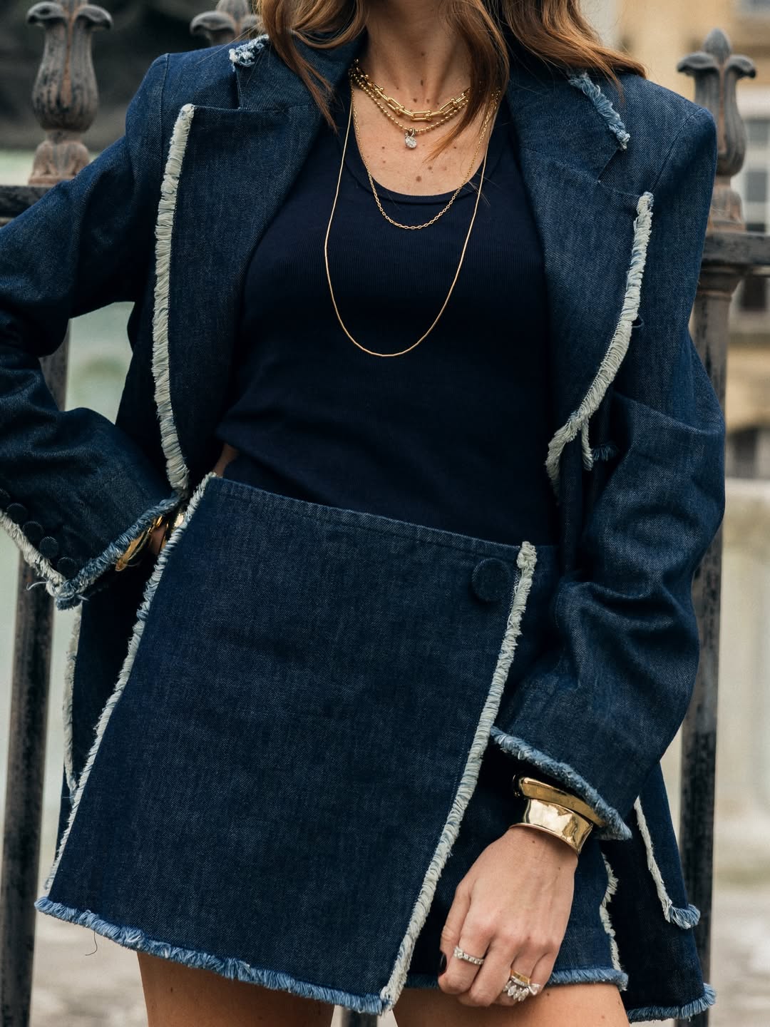 Detalhe de look AMMIS em jeans com sobreposição e acessórios.