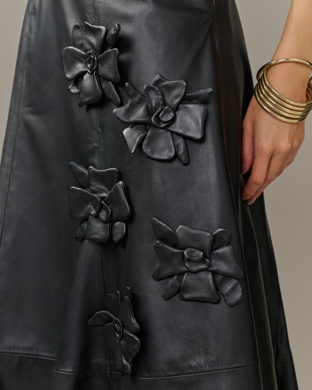 Saia midi preta em couro de cabra com modelagem godê e aplicações florais AMMIS