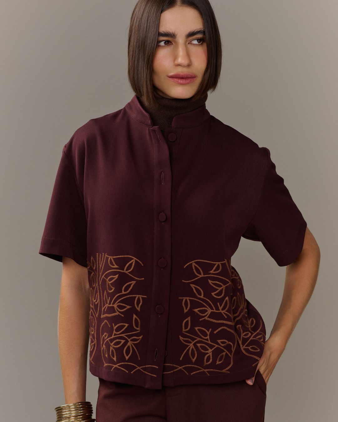 Camisa feminina marrom de manga curta com bordado de folhagens na barra AMMIS