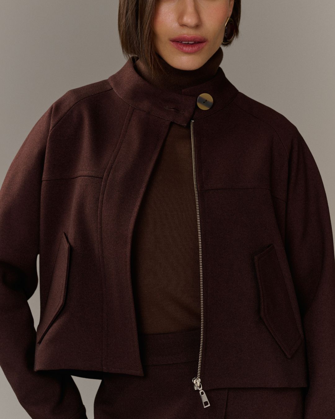 Jaqueta cropped marrom de alfaiataria com gola estruturada e zíper frontal AMMIS